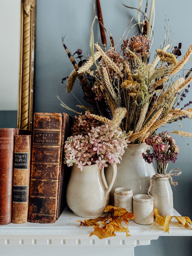 shelf with pitchers and vases of dried flowers and plants for fall