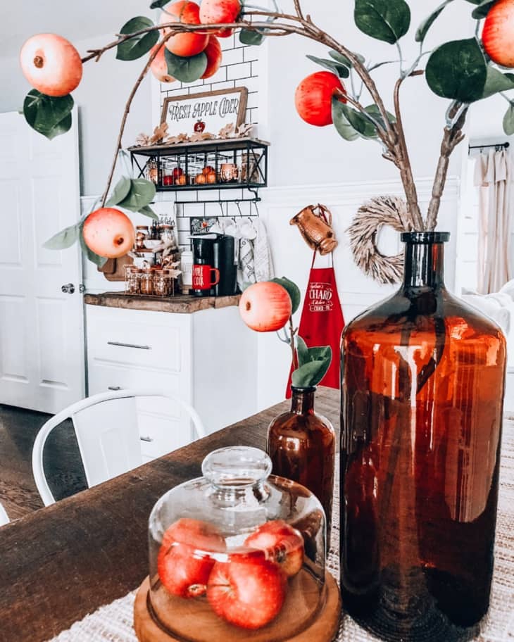 Kitchen with vases on table filled with faux apple branches