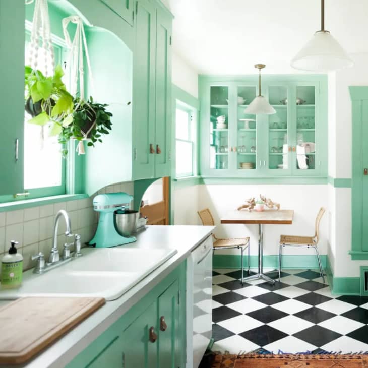 mint kitchen cabinetry with black and white checkerboard tile