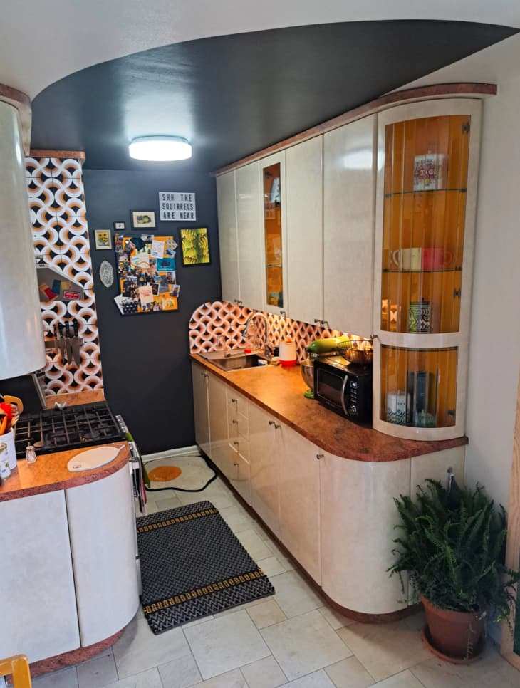 a small apartment kitchen with curved cabinetry