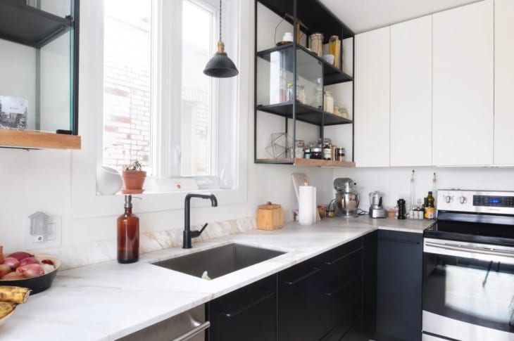 a modern black and white kitchen with open shelving with display cases