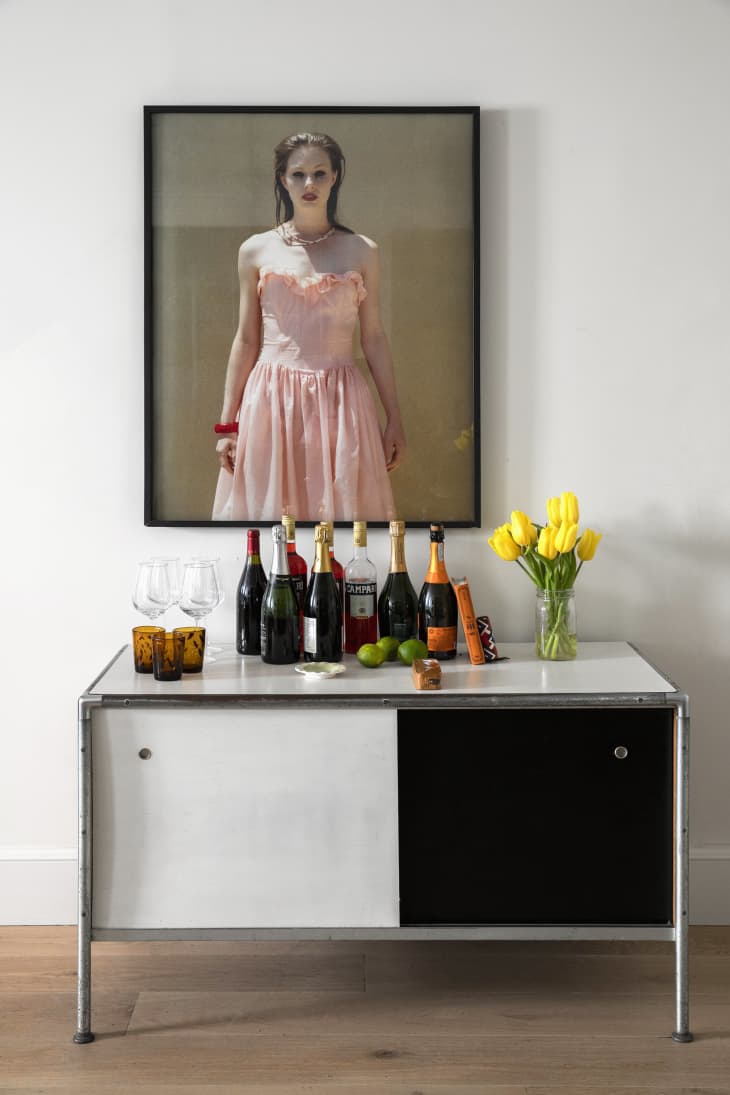 vintage bar with sliding door, champagne, portrait of a woman in pink dress, yellow tulips, wood floors