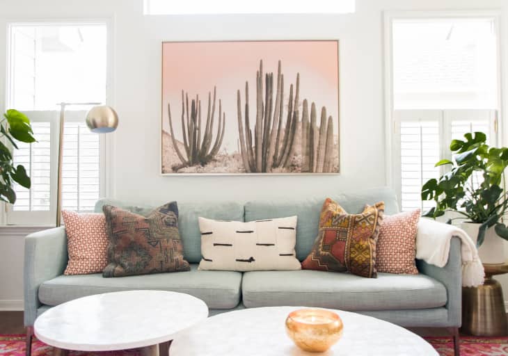 a pastel living room with a gold floor lamp behind the sofa