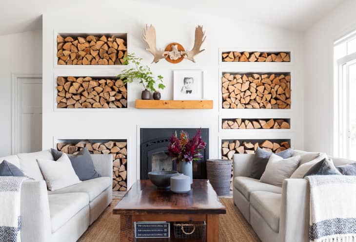 a white room with a wall of firewood