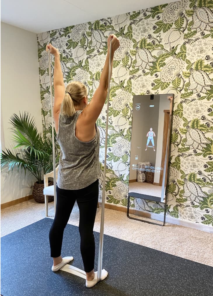 accent wallpaper on wall with workout mirror that displays workout with you