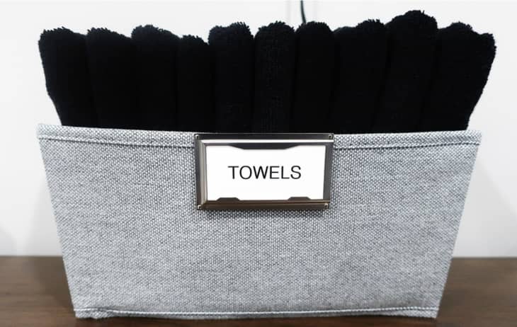 grey soft basket with black towels folded