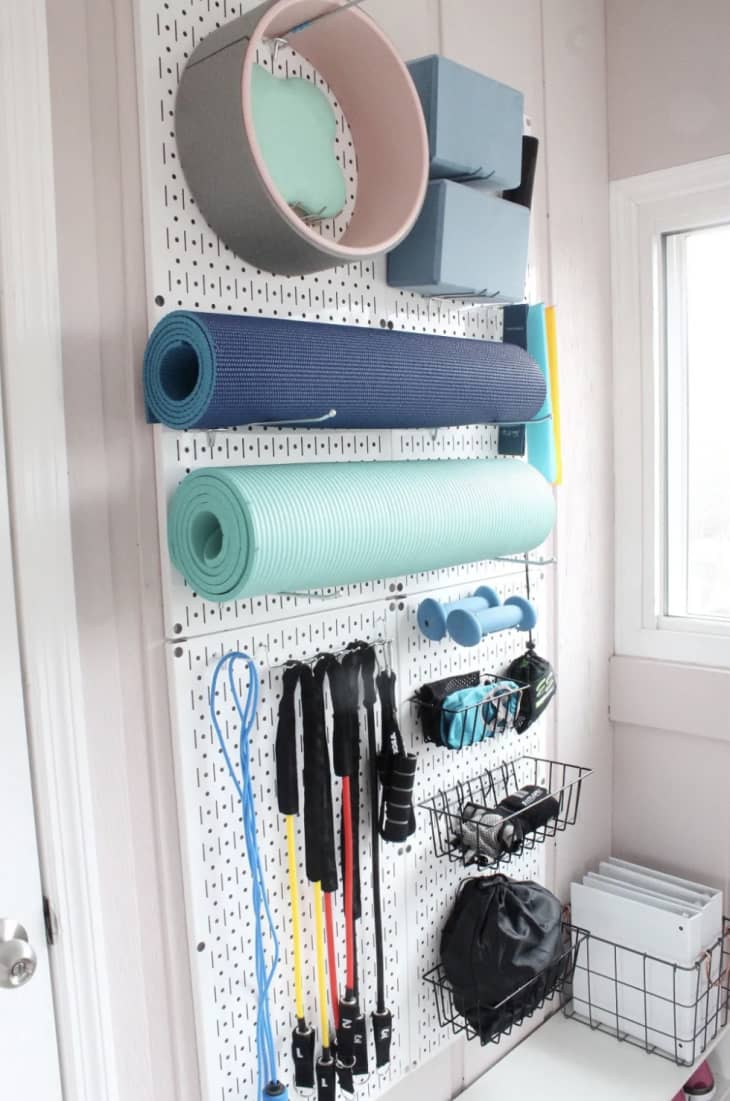 peg board with exercise equipment organized on wall
