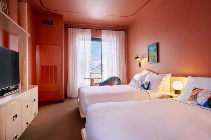 Coral colored room with 2 double beds at Hotel Genevieve