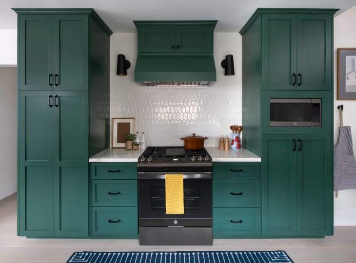 teal cabinets with framing and black handles