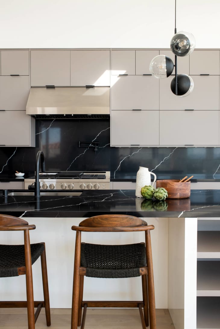 cream slab style cabinets with black countertops