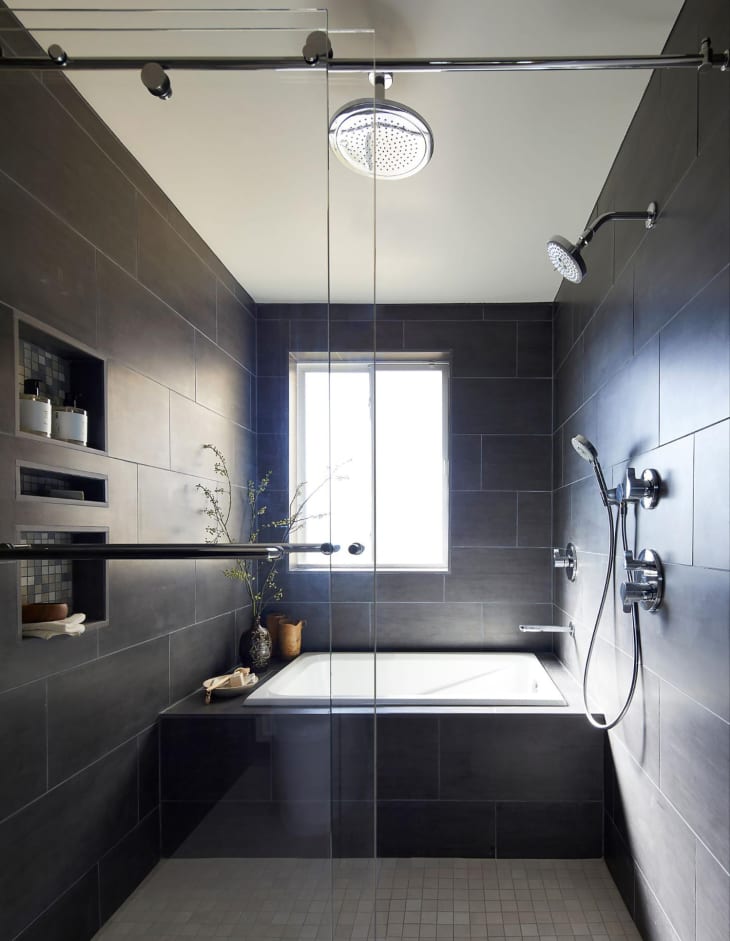 Waterfall shower head in walk in shower with charcoal tiles.