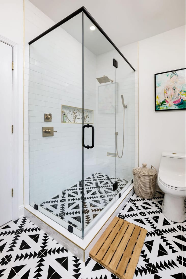 Black and white tiles in bathroom with glass door walk in shower.