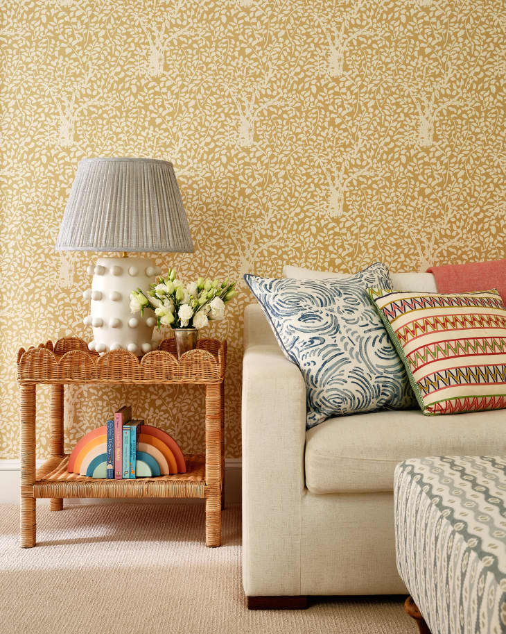 Yellow wallpaper with tree and leaf motif in living room.