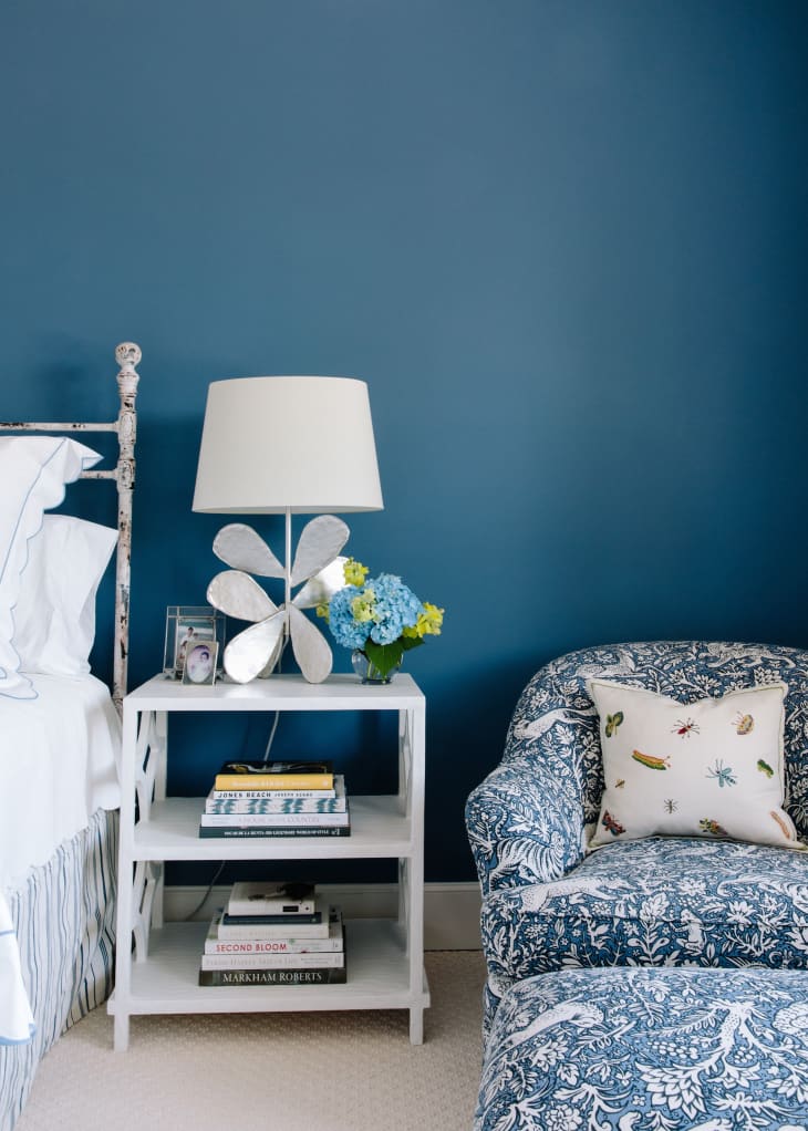 Blue painted room with blue patterned fabric arm chair and ottoman.