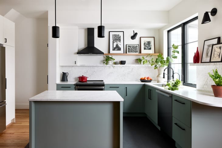 White kitchen with green cabinets below and open shelving above the counter