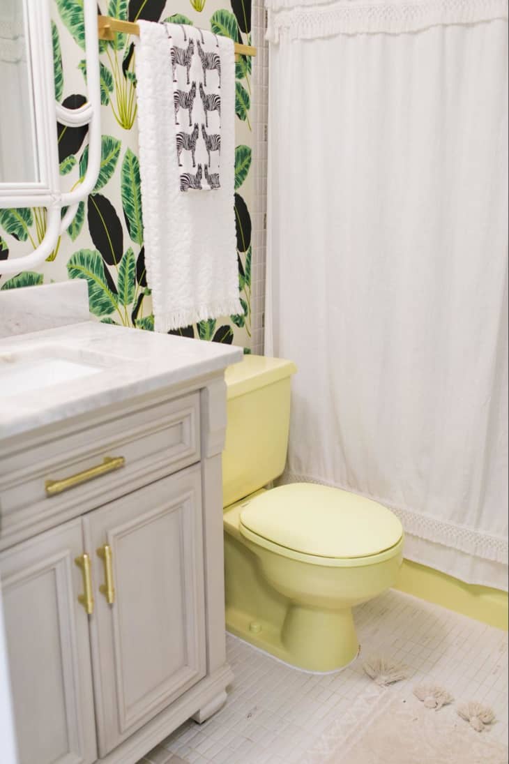 Bathroom with pale yellow toilet and botanical wallpaper