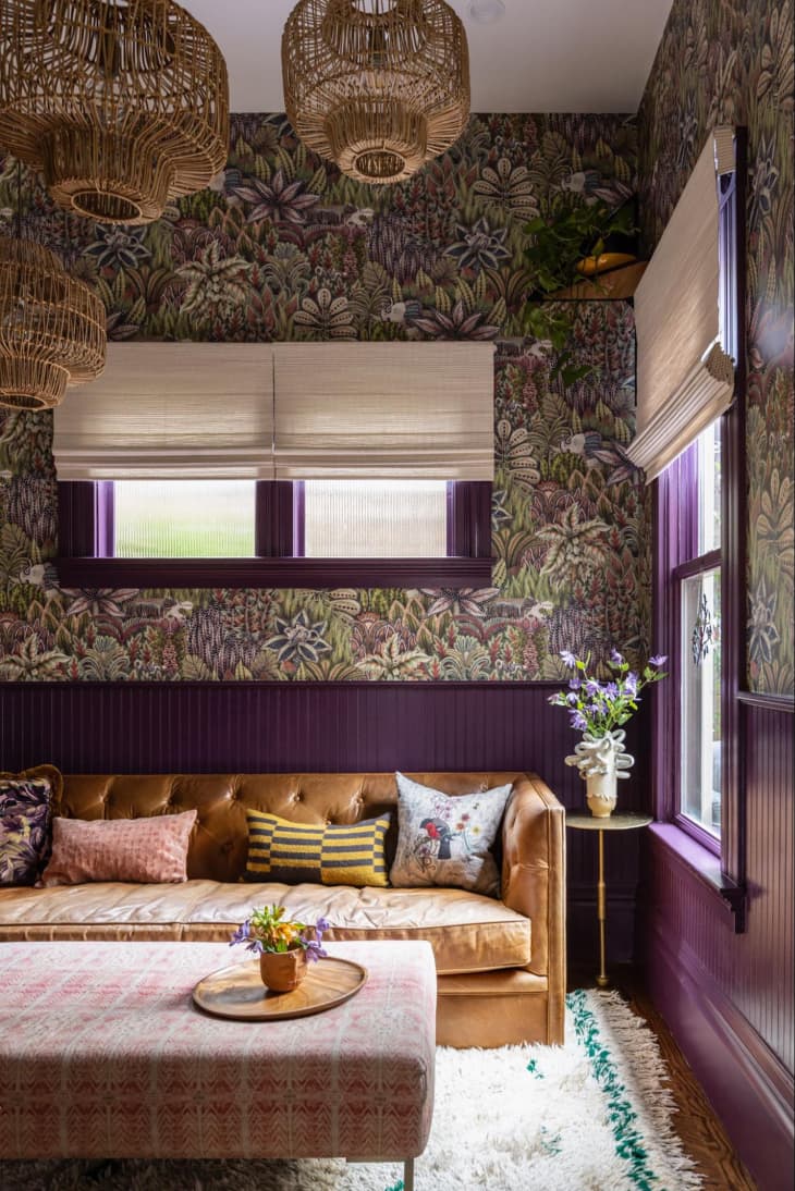 Purple wainscoting in wallpapered living room.