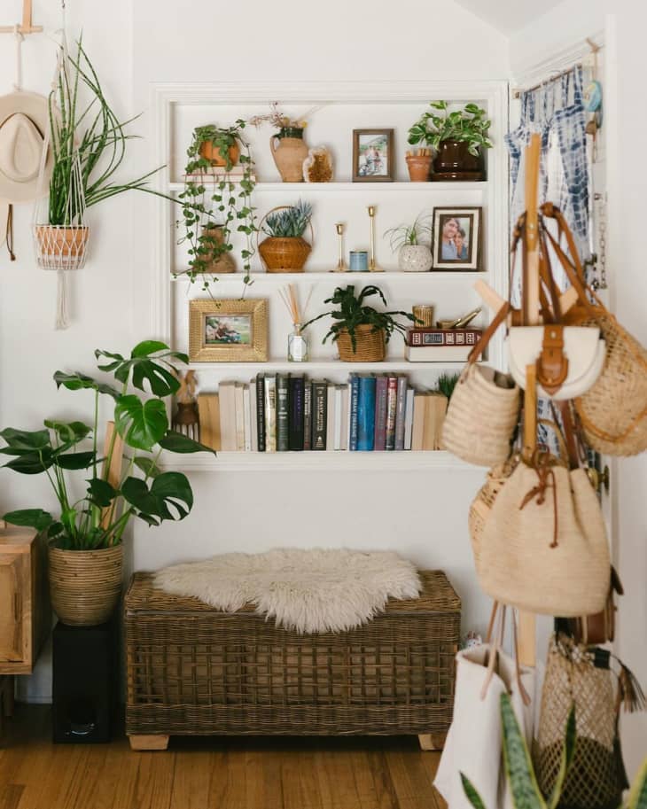built in white bookshelves in boho room with lots of plants