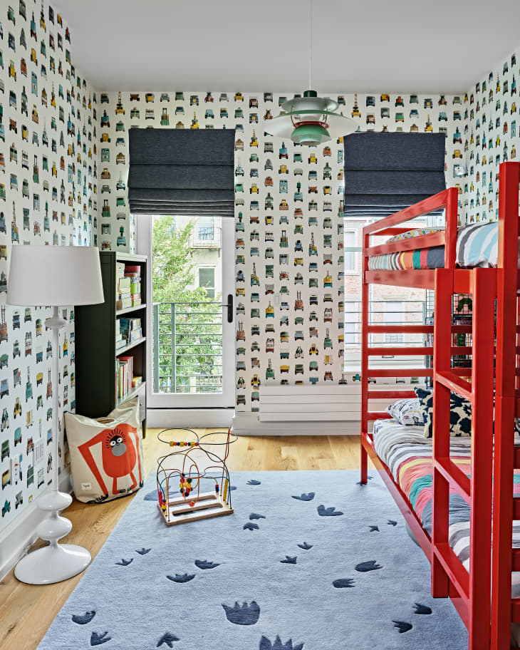 kids room with patterned wallpaper and red bunk bed