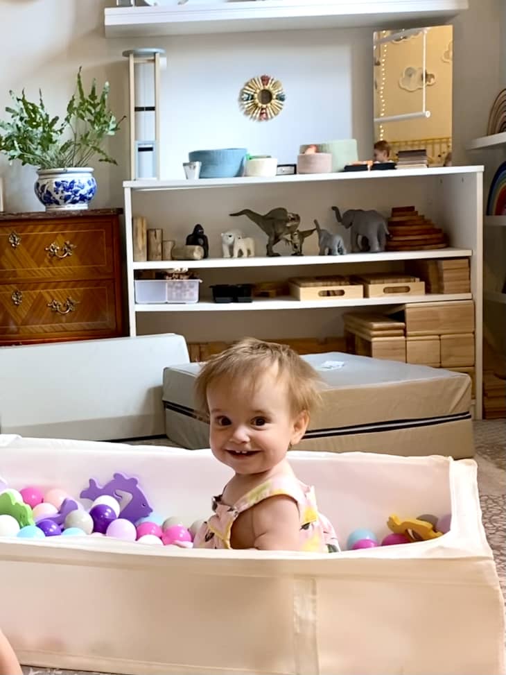 Baby playing in homemade ball pit that's been crafted from an IKEA STUBB storage case