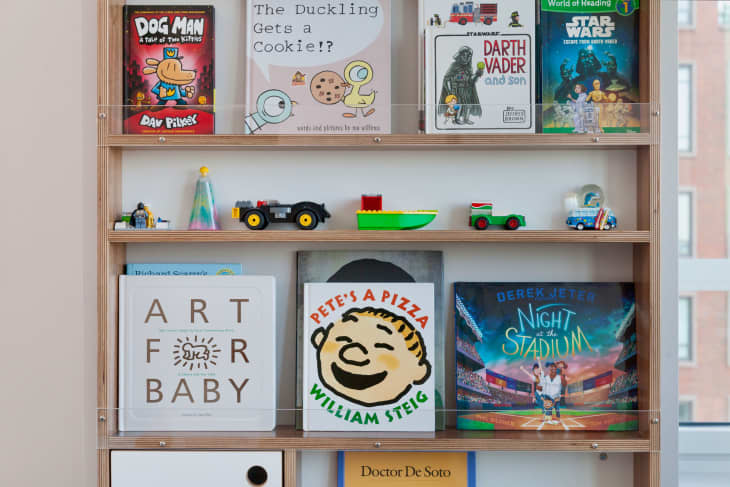 Children's books on a bookshelf in a multi-purpose kids room.