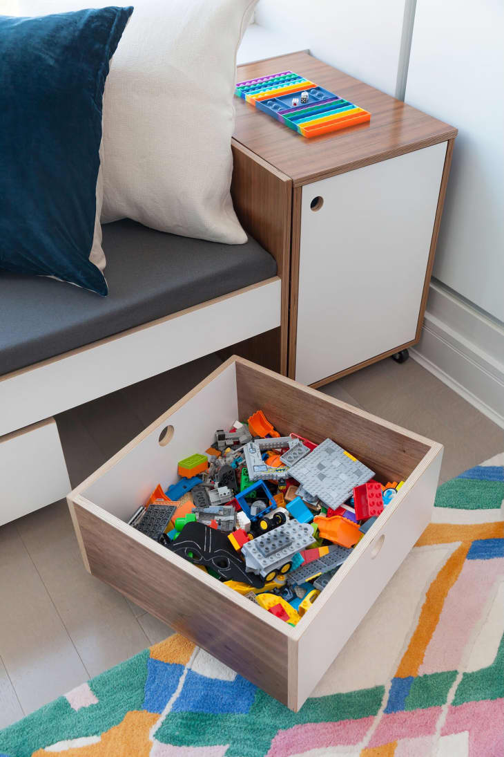 Kids toys in drawer stored in under sofa storage.