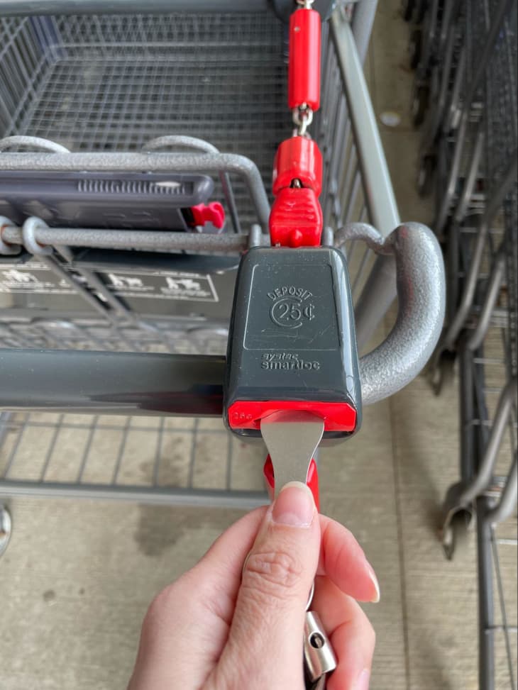 person unlocking Aldi shopping cart