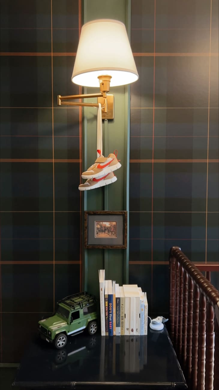 Baby sneakers hung from sconce in baby nursery.