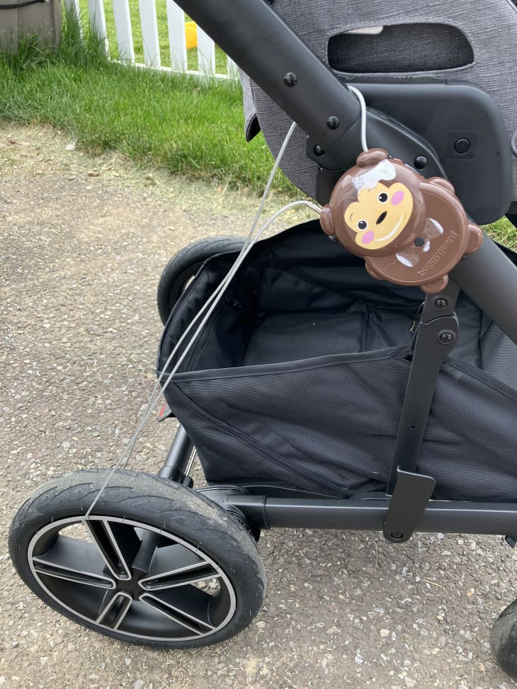 black baby stroller on path that has been locked by simple bike/stroller lock