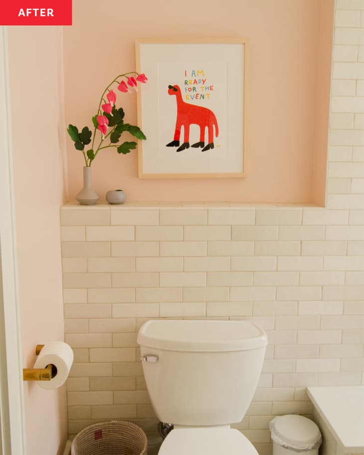 Kids art print hung on wall behind toilet in newly renovated bathroom.