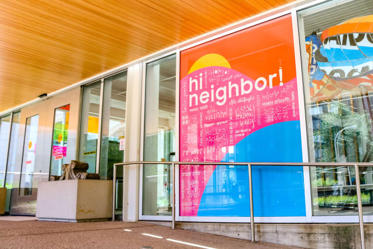 Exterior windows of the Children's Museum of Pittsburgh with sign saying "hi neighbor!" in multiple languages
