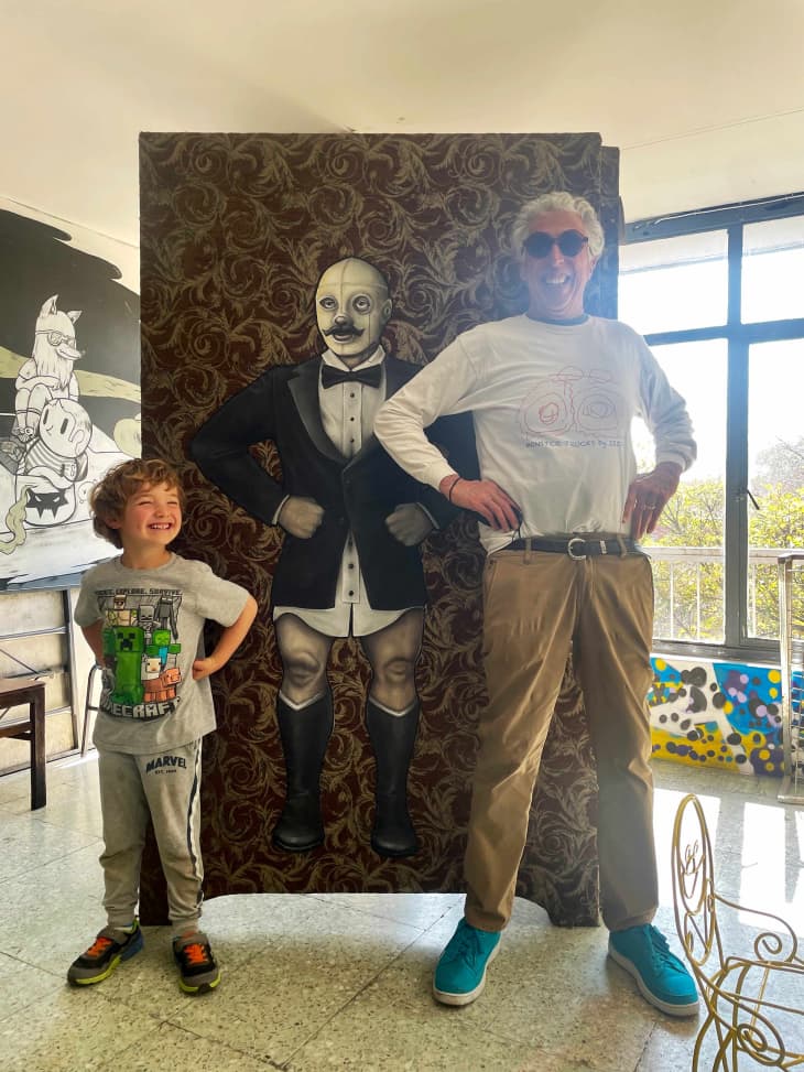 child and grandparent posing in front of painting in Mexico City
