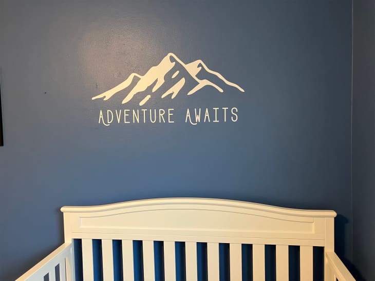 Adventure Awaits signage on nursery wall.
