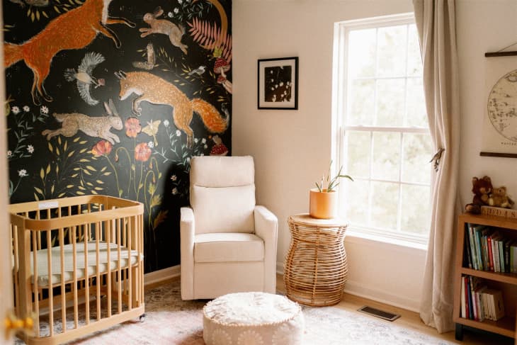 Nursery with forest animal mural and furniture/textiles in pale neutral tones