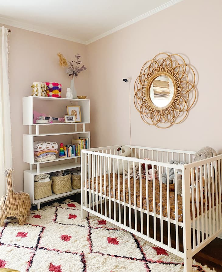 nursery with blush walls, shag rug, and white and natural details