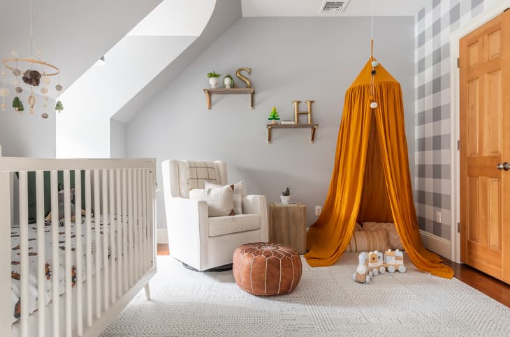 gray and white nursery with an orange tent and gingham wallpaper