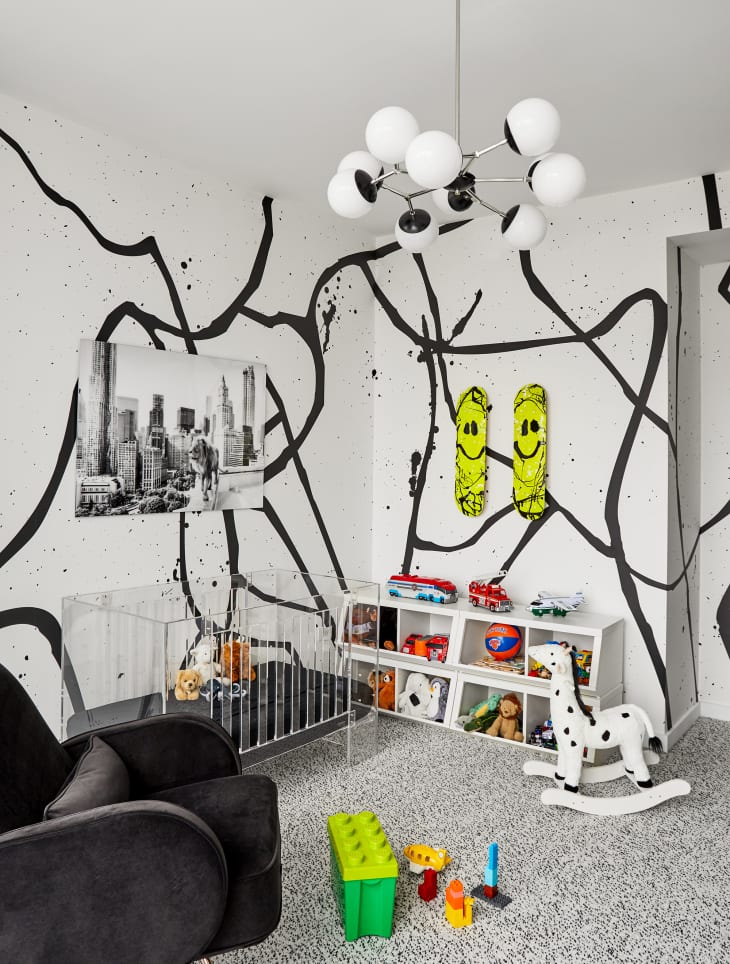 Nursery with lucite crib and black and white street art style wall painting