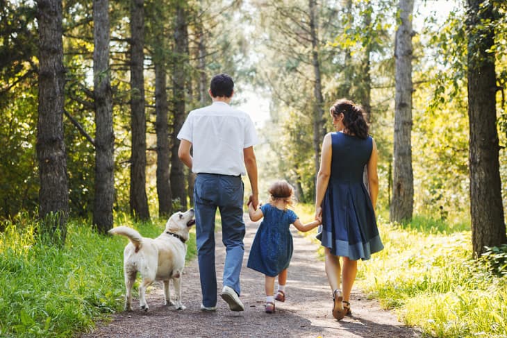 family taking a walk together with dog