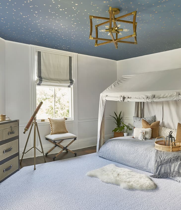 safari themed bedroom with starry blue wallpaper on the ceiling, leopard print carpet, and tented bed