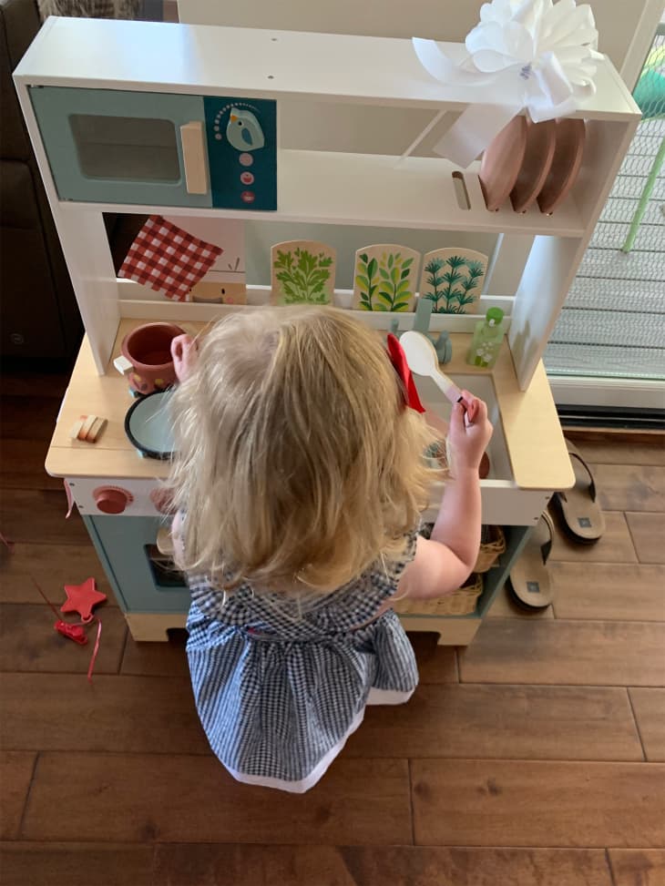 Child playing with Tender Leaf play kitchen.