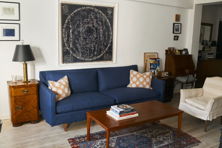 Navy blue sofa in living room with orange pillows