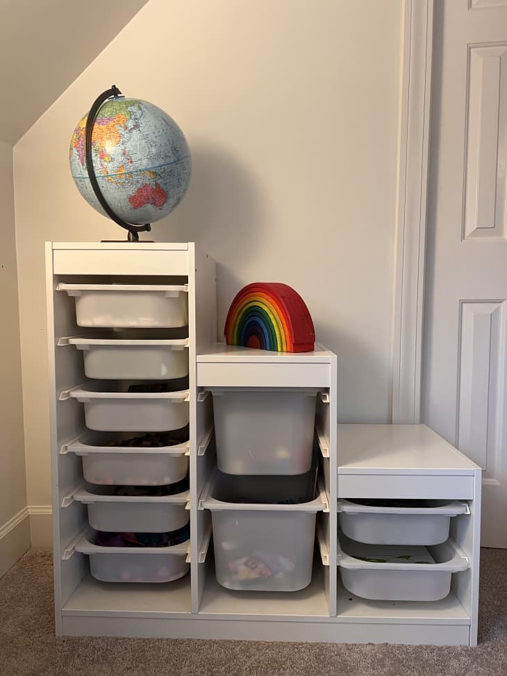 IKEA trofast LEGO storage with a globe and a wooden rainbow toy on top