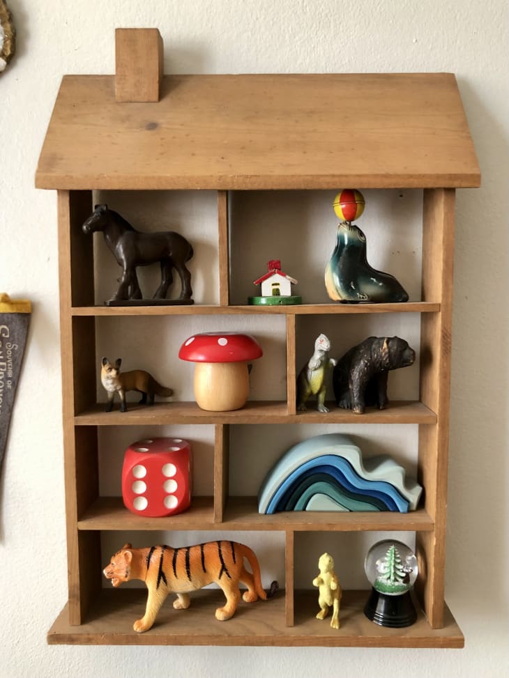 wooden toys on vintage wood house-shaped wall shelf