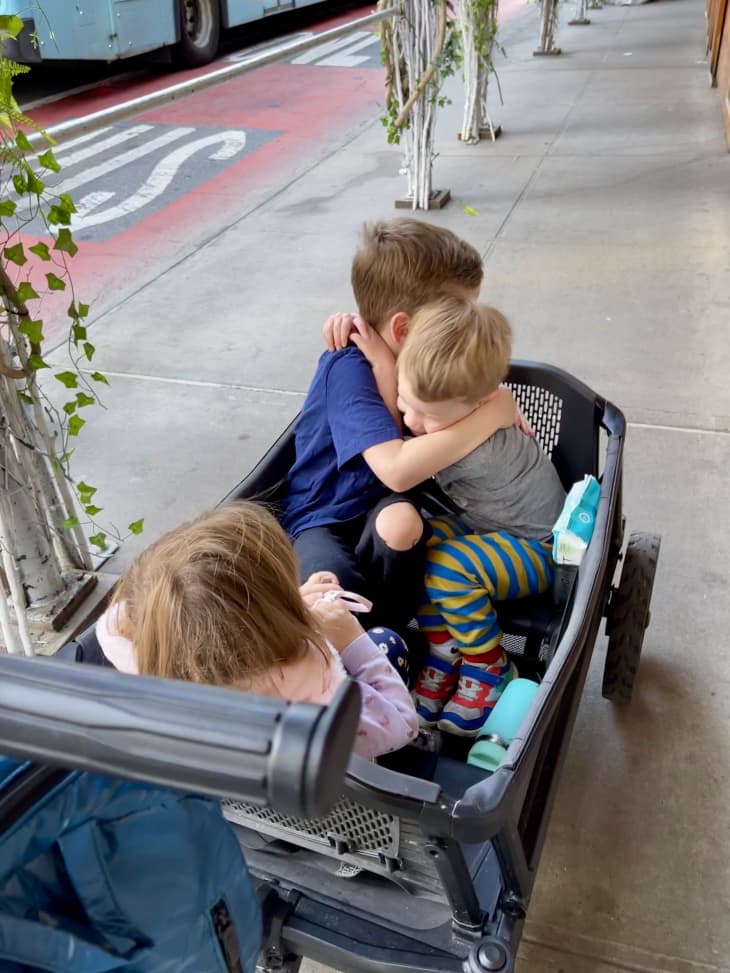 two kids hugging in a veer wagon