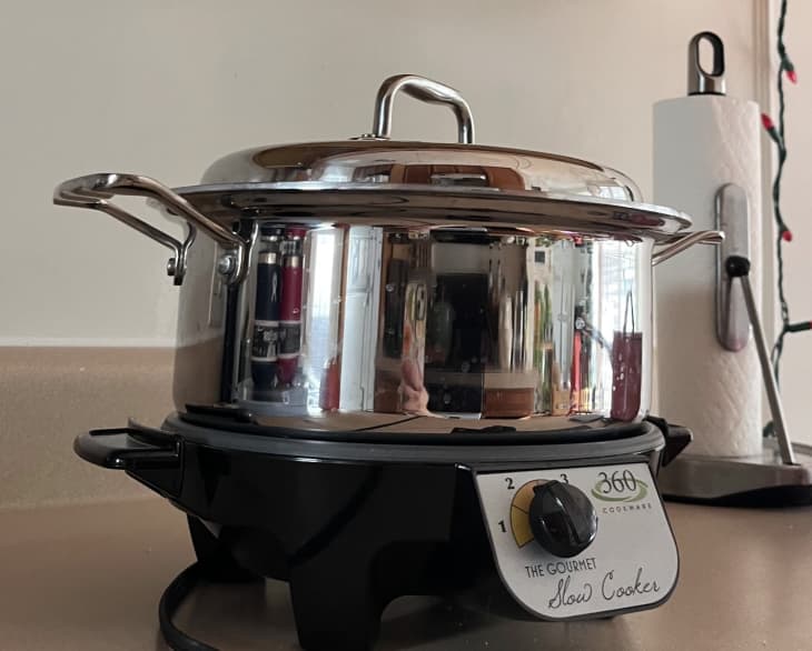 stainless steel pot on top of a black slow cooker base