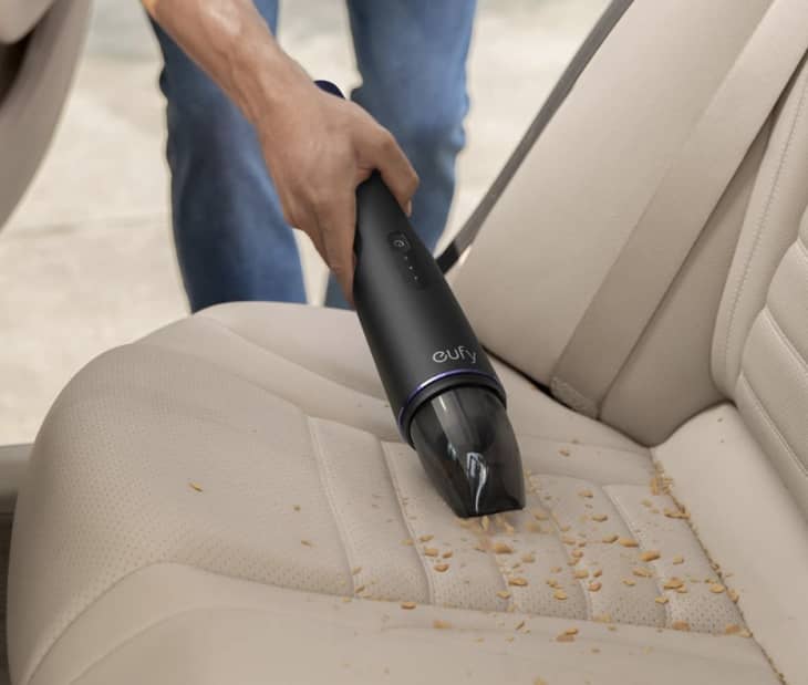 black handheld vacuum cleaning car interior