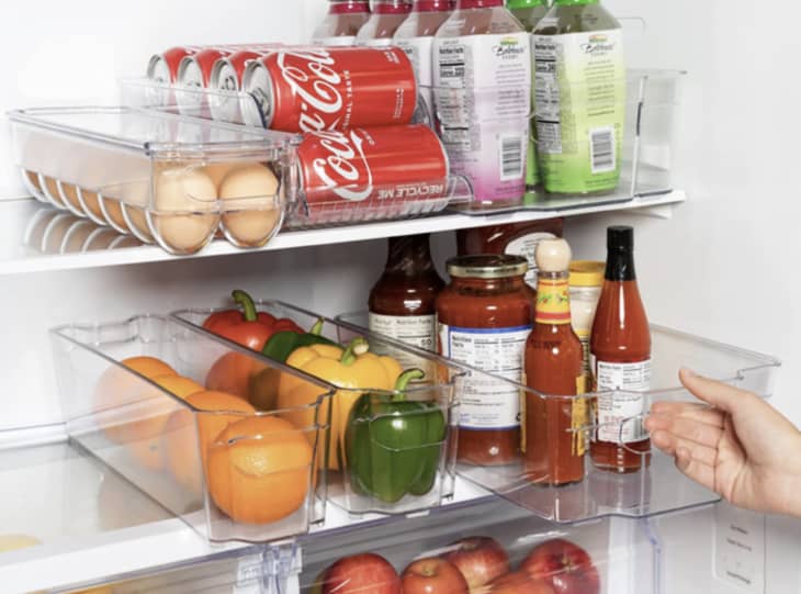 clear plastic bins holding groceries inside fridge