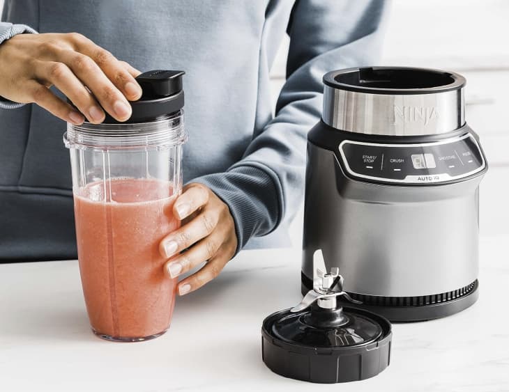 person making pink smoothie with blender