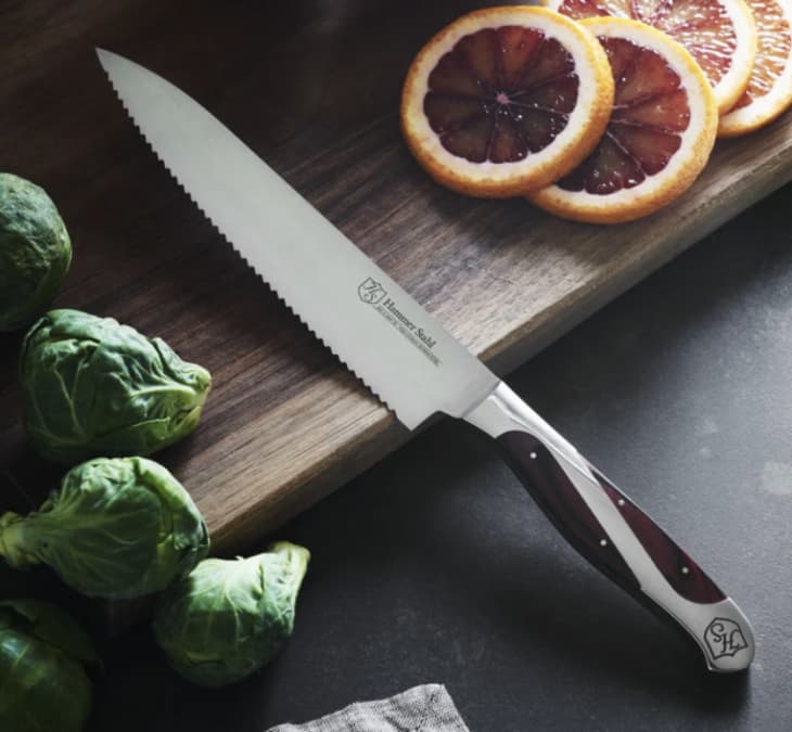 silver serrated utility knife on cutting board