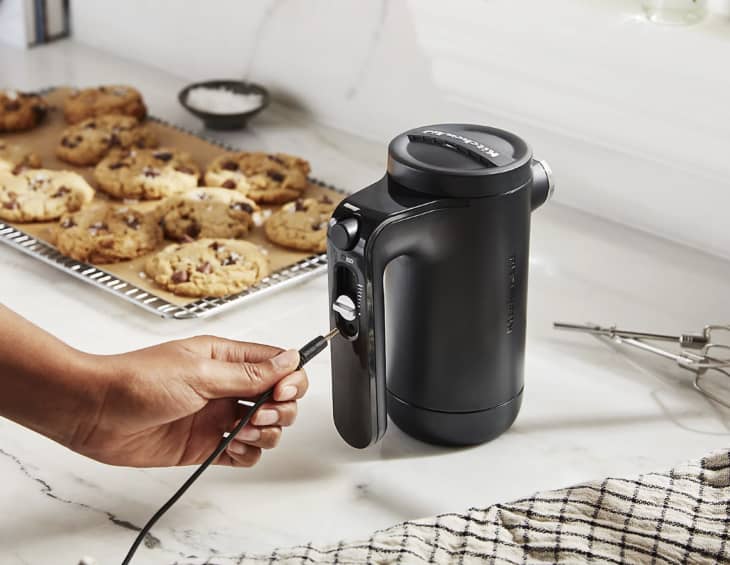black hand mixer next to pan of cookies